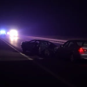 Scene of a car crash with emergency responders in the background, symbolizing the consequences of DUI.